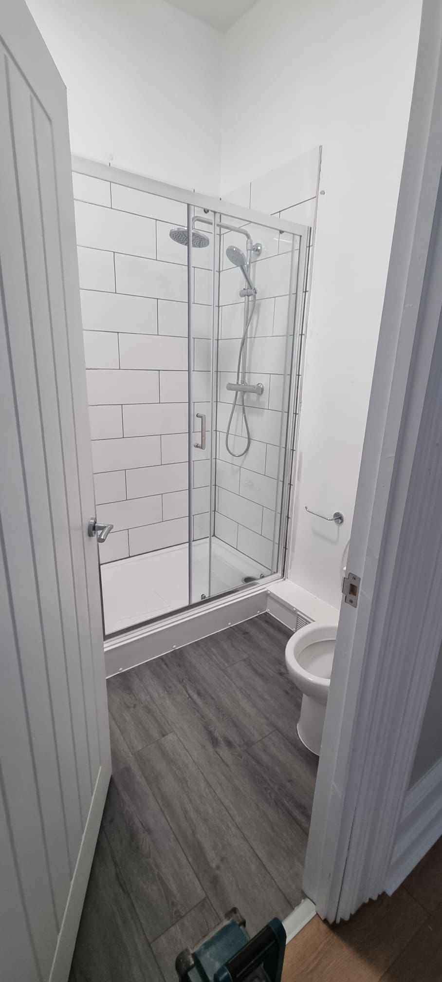 Compact bathroom shower enclosure with white metro tiles