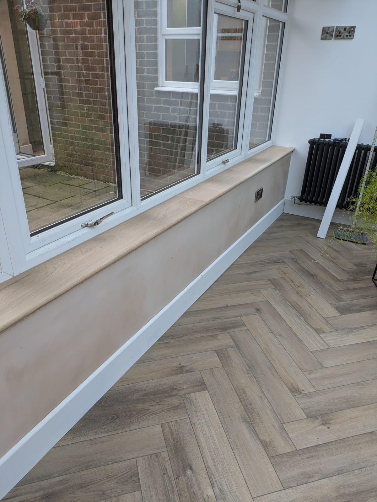 Conservatory interior with herringbone flooring beside windows