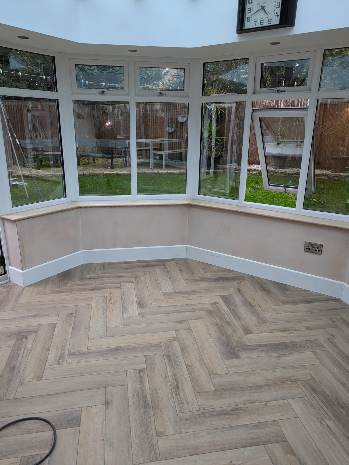 Conservatory interior with herringbone floor and garden views