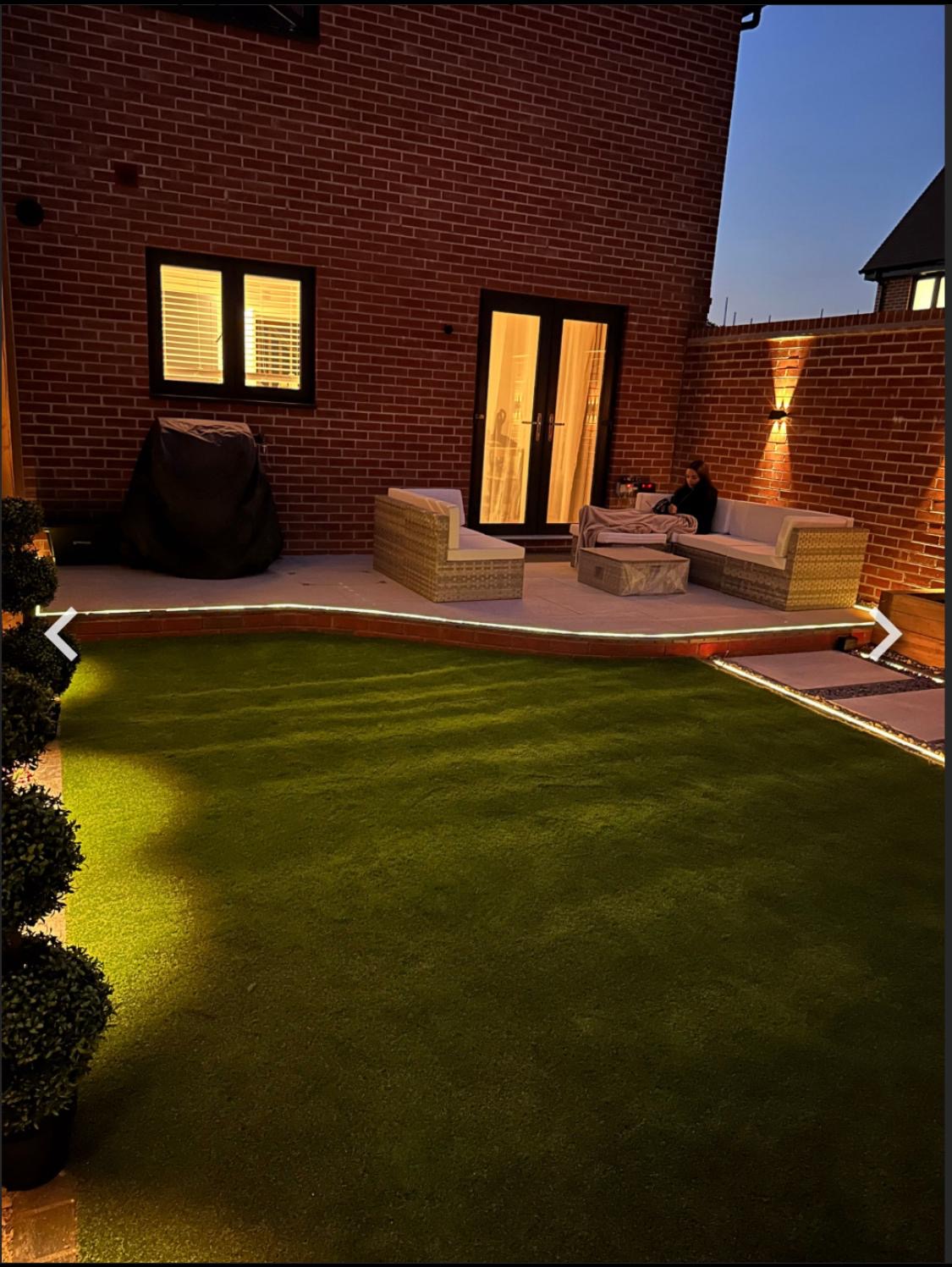 Evening patio seating area with garden lighting