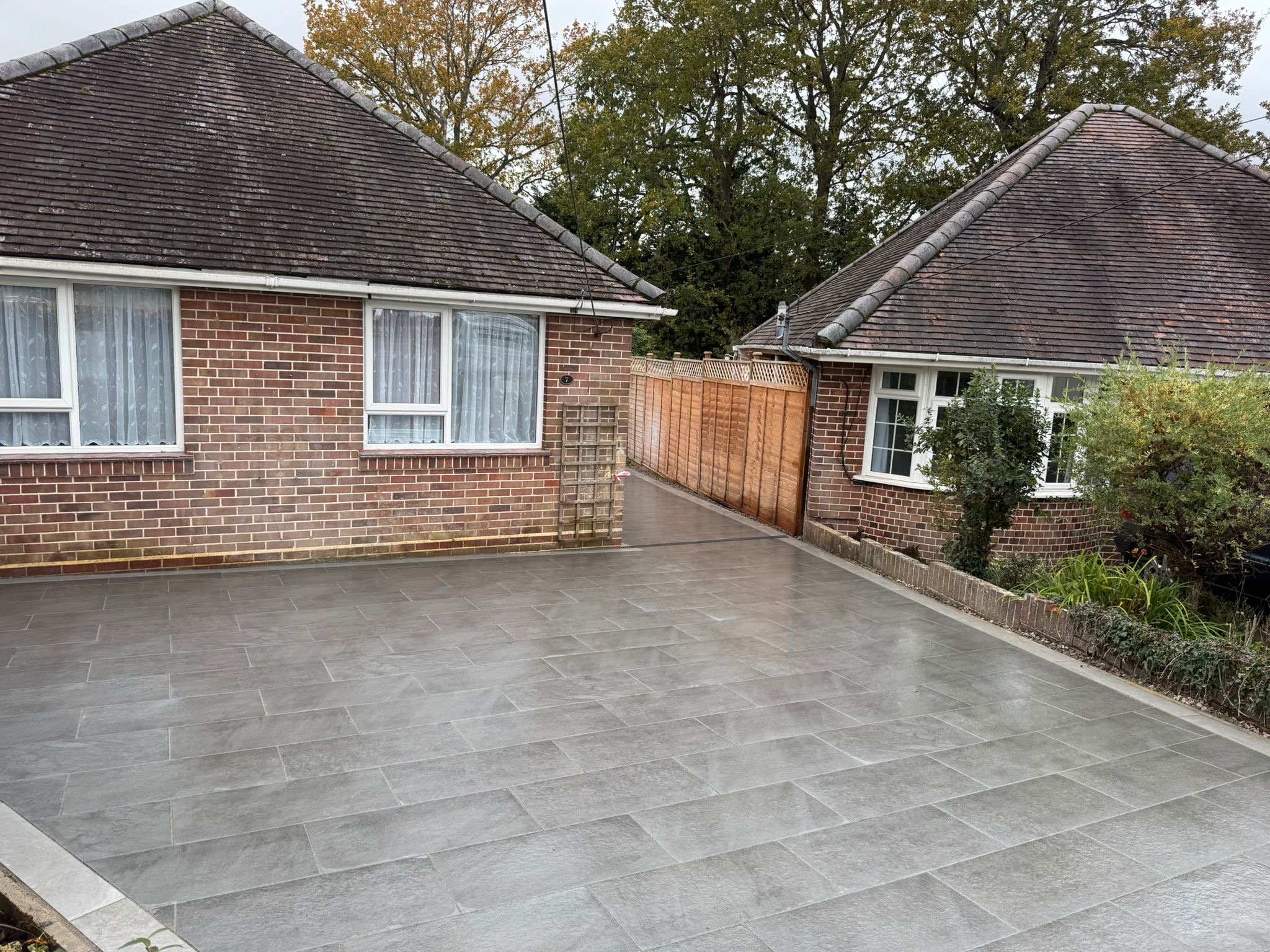 Grey porcelain driveway and side access between two properties