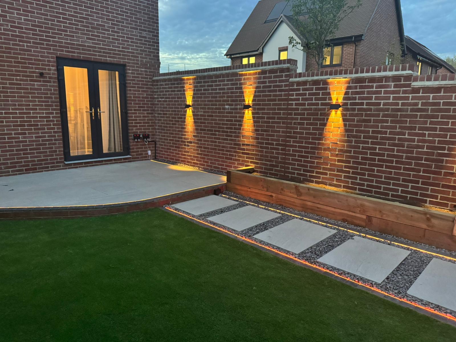Landscaped garden with patio, lighting and stepping stones