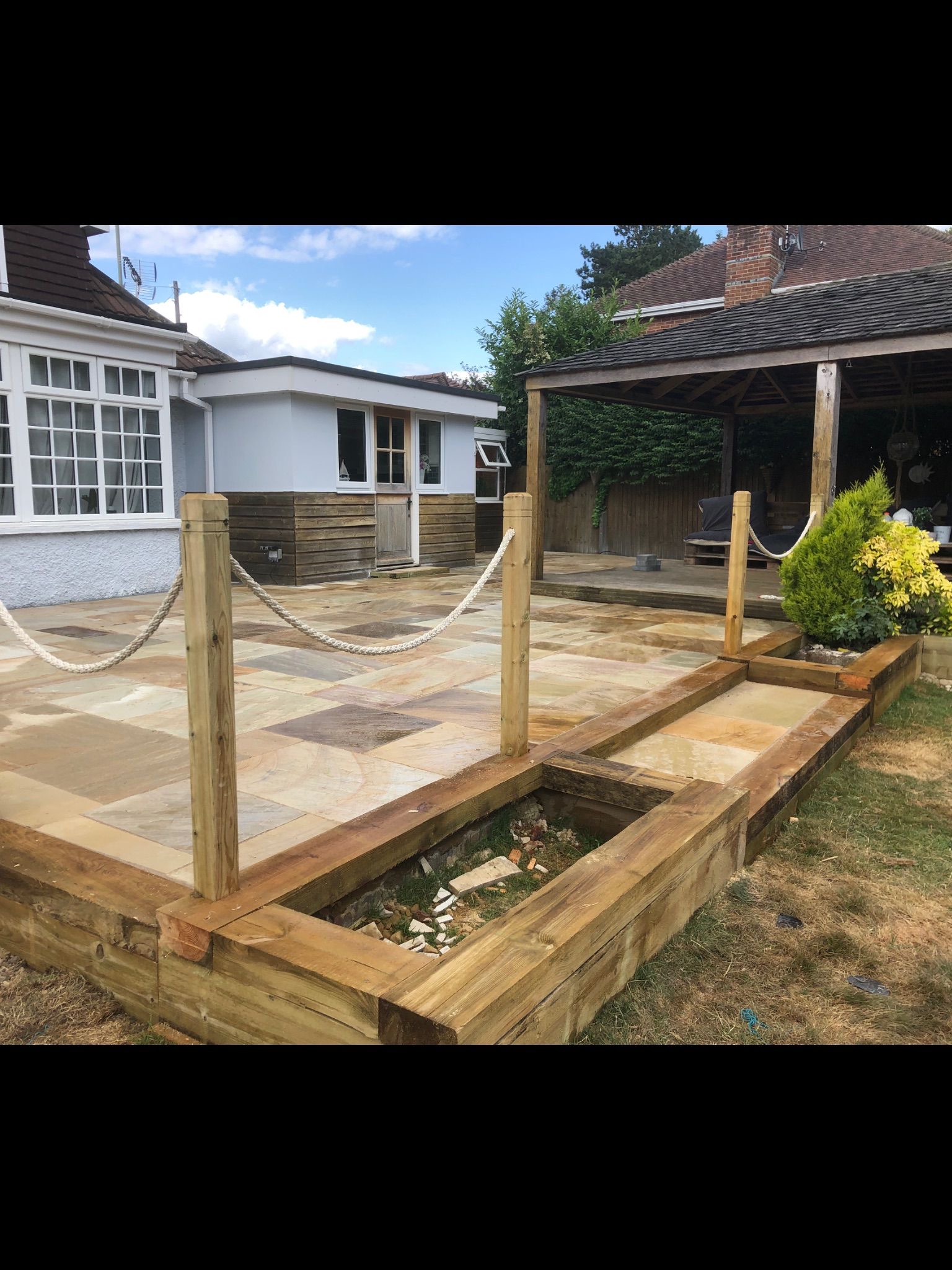 Natural stone patio with timber posts, rope detail and covered seating