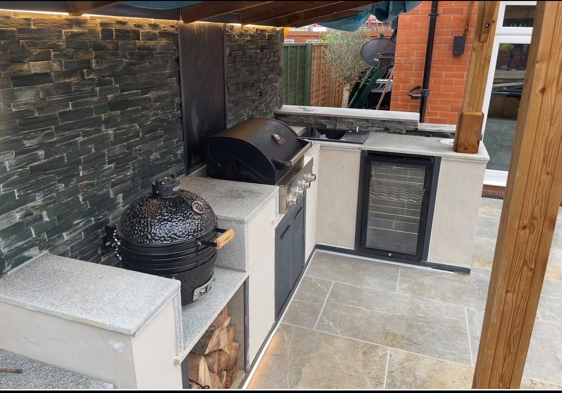 Covered outdoor kitchen with built-in barbecues and stone worktops