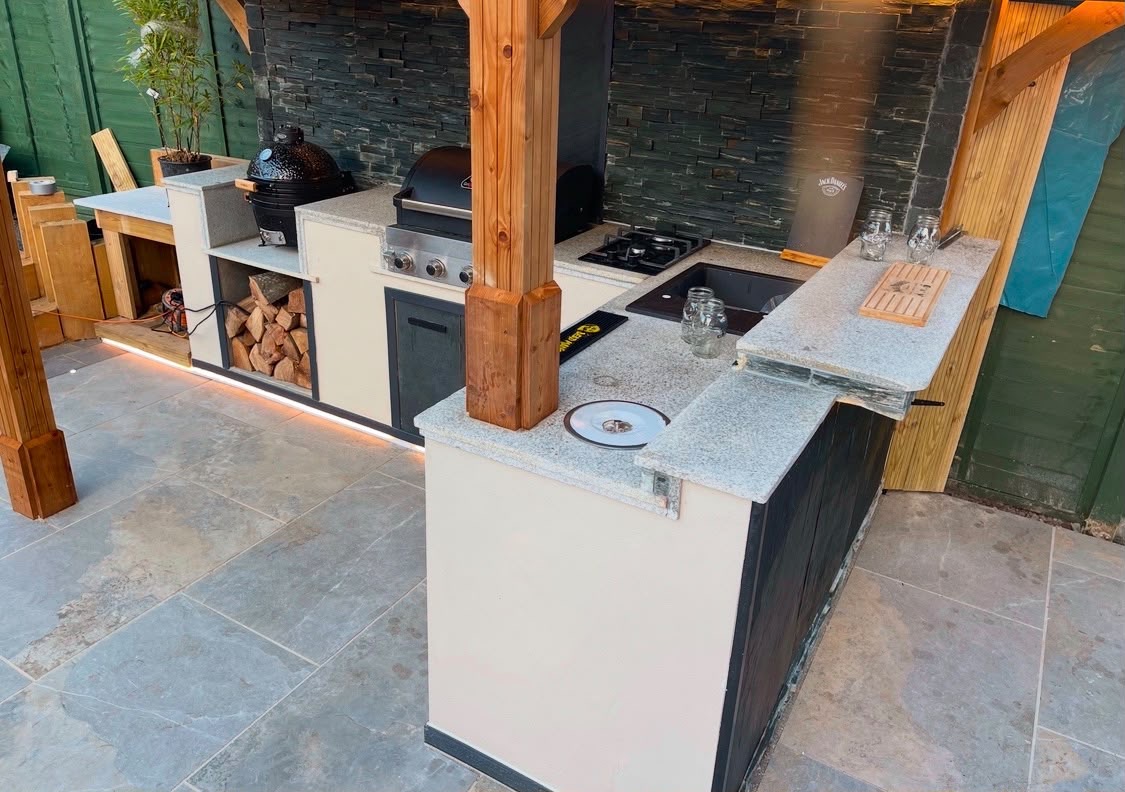 Outdoor kitchen with wraparound stone worktop and sink