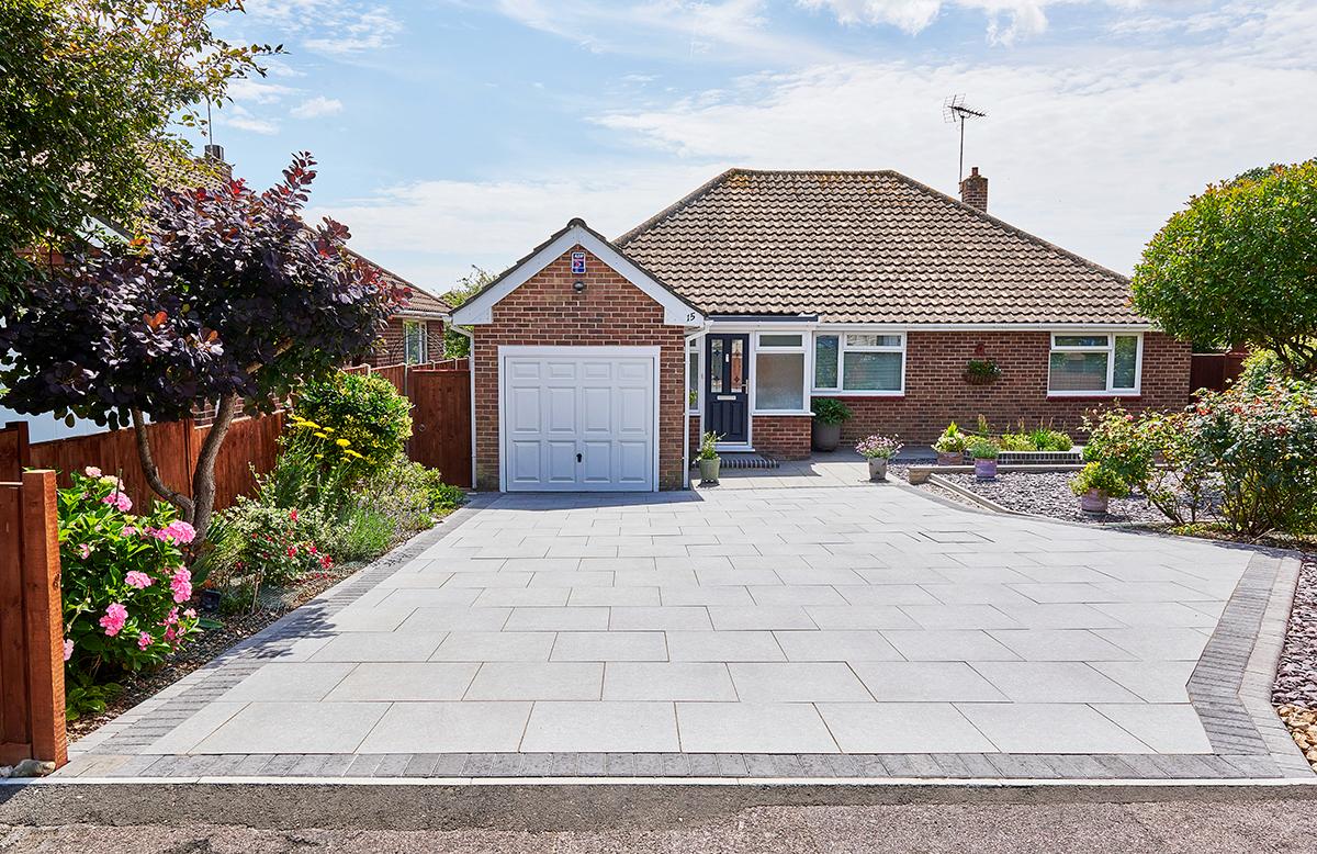 Front view of a porcelain driveway with planted borders