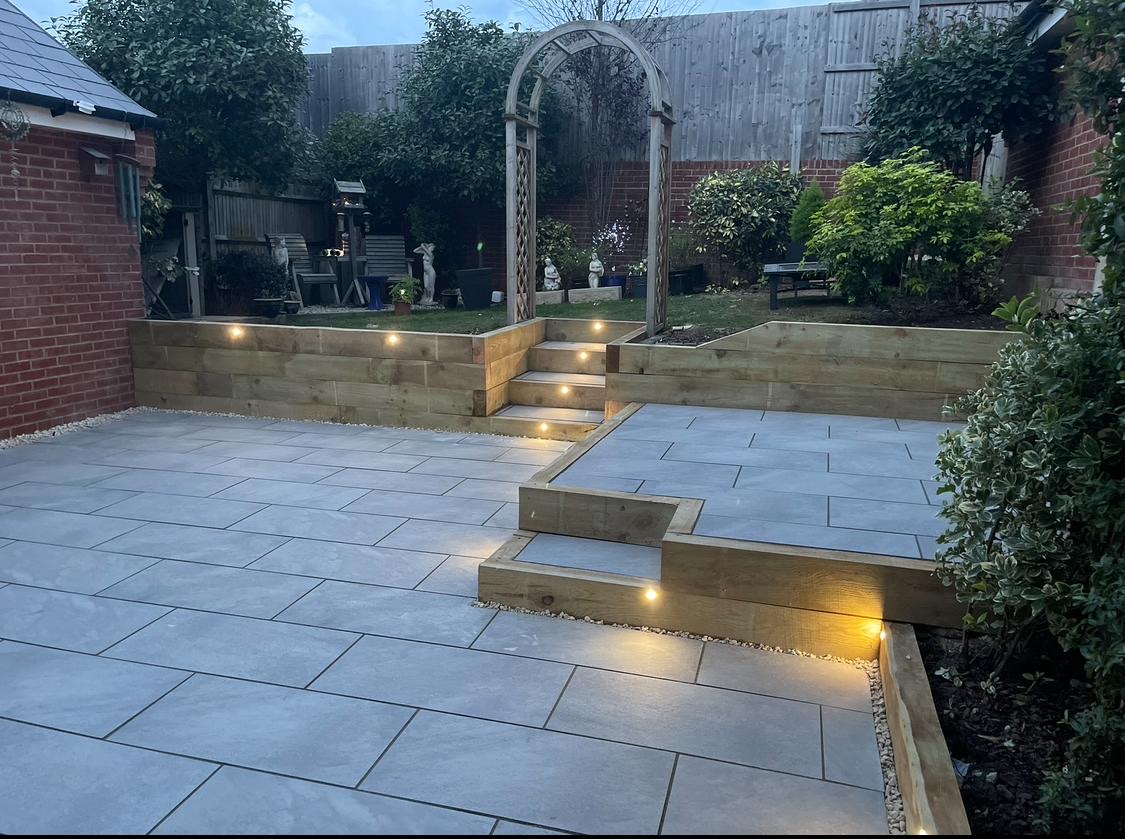 Porcelain patio steps and raised garden with warm lighting