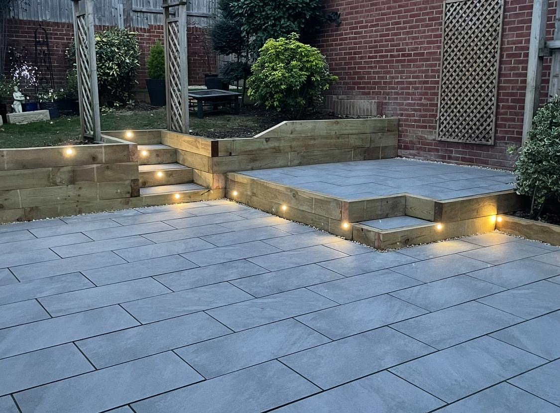 Porcelain patio with raised timber edging and step lights