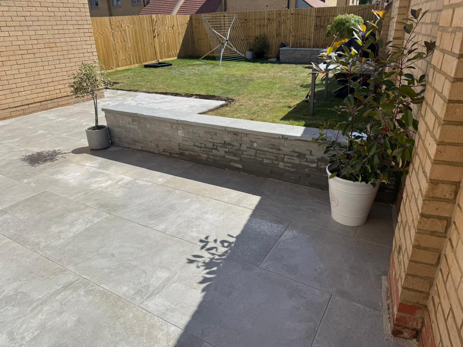 Porcelain patio with raised wall and lawn area
