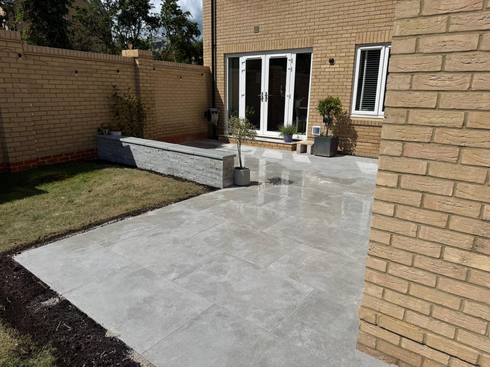 Porcelain patio with raised bed and garden lawn