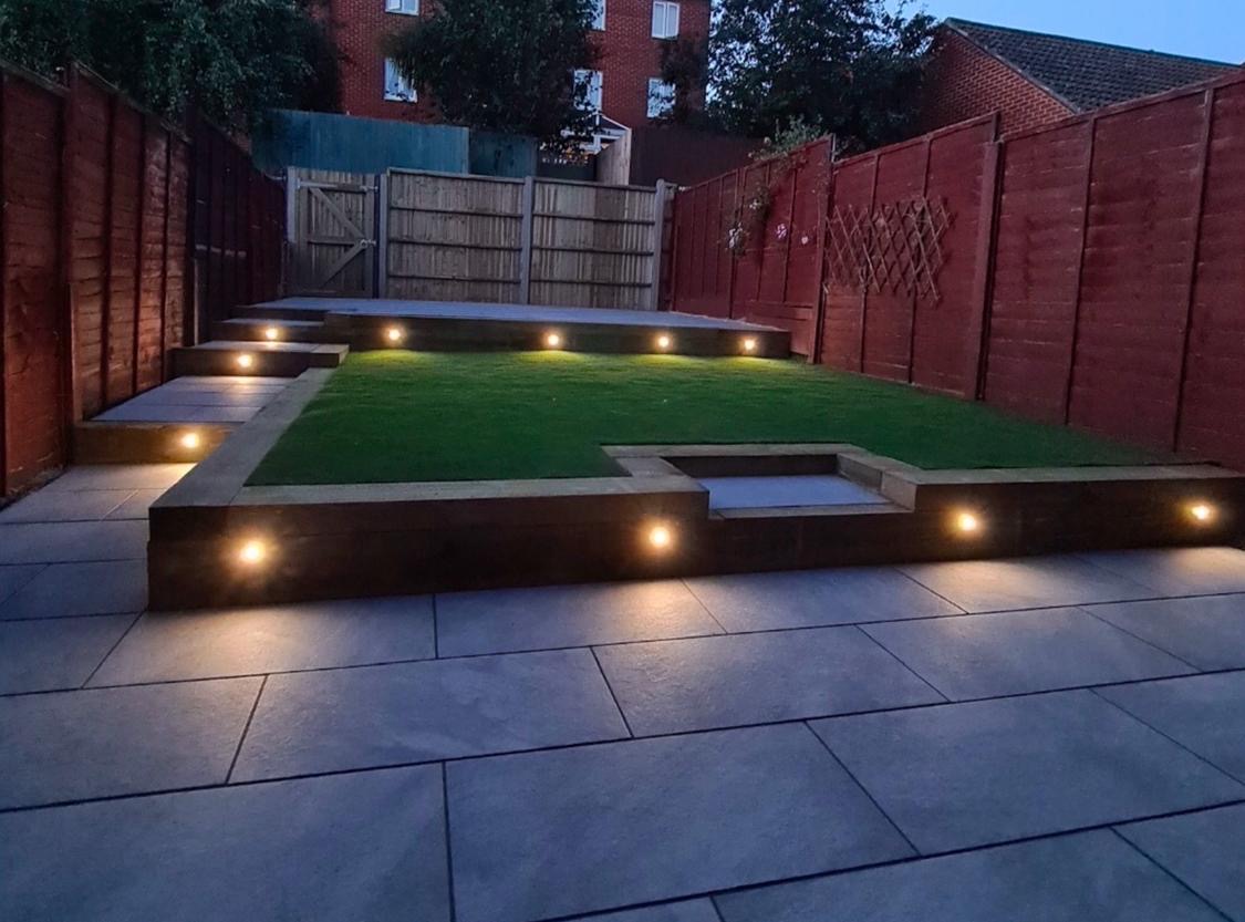 Raised garden with patio lighting at dusk