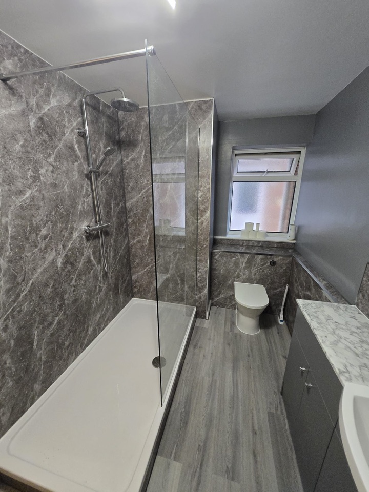 Grey bathroom with walk-in shower and marble effect panels