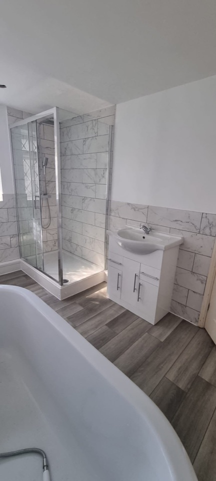 Bathroom renovation with bath, shower enclosure and marble effect wall tiles