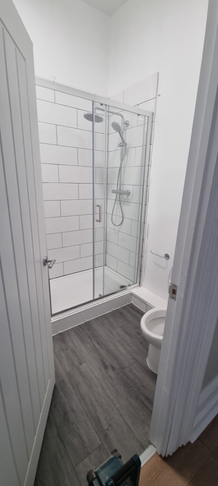 Compact bathroom shower enclosure with white metro tiles