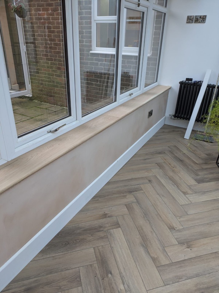 Conservatory interior with herringbone flooring beside windows