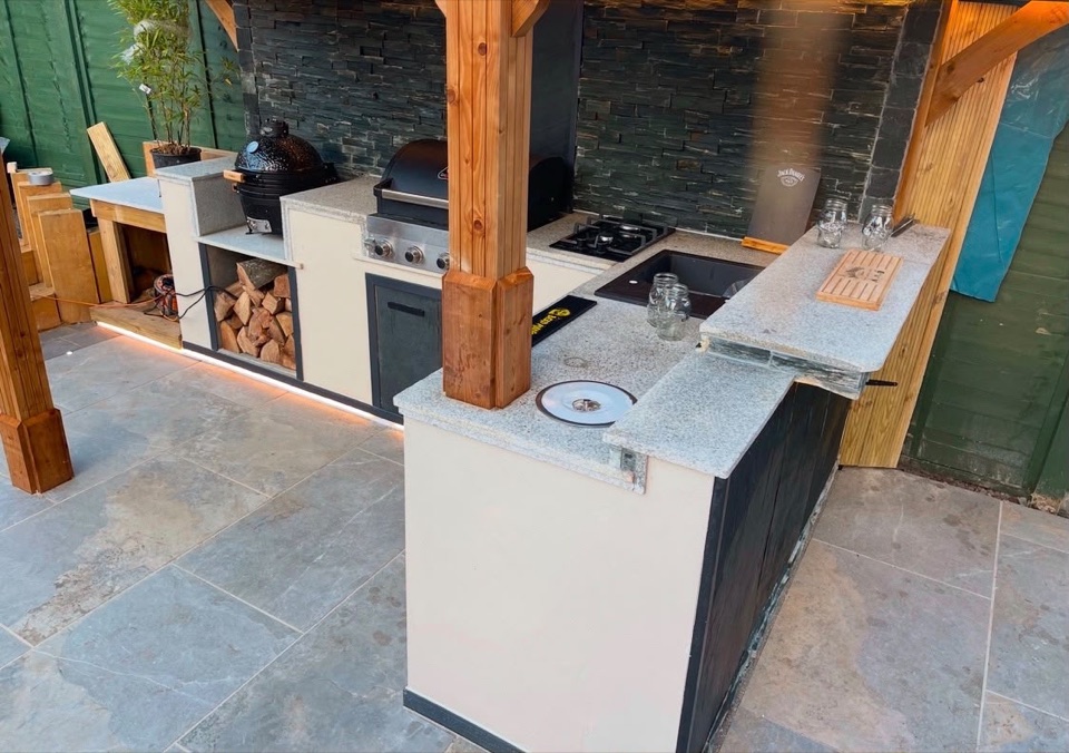 Outdoor kitchen with wraparound stone worktop and sink
