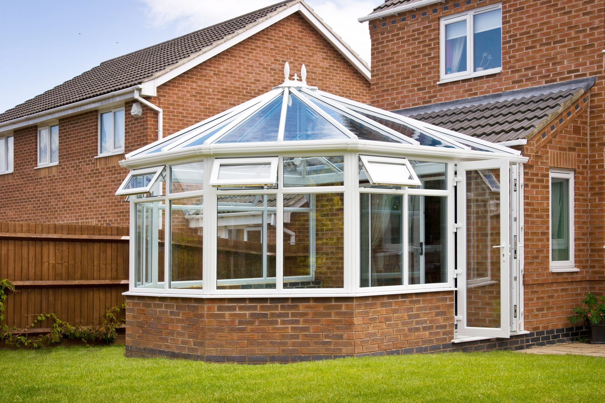 White conservatory extension with brick base and glazed roof