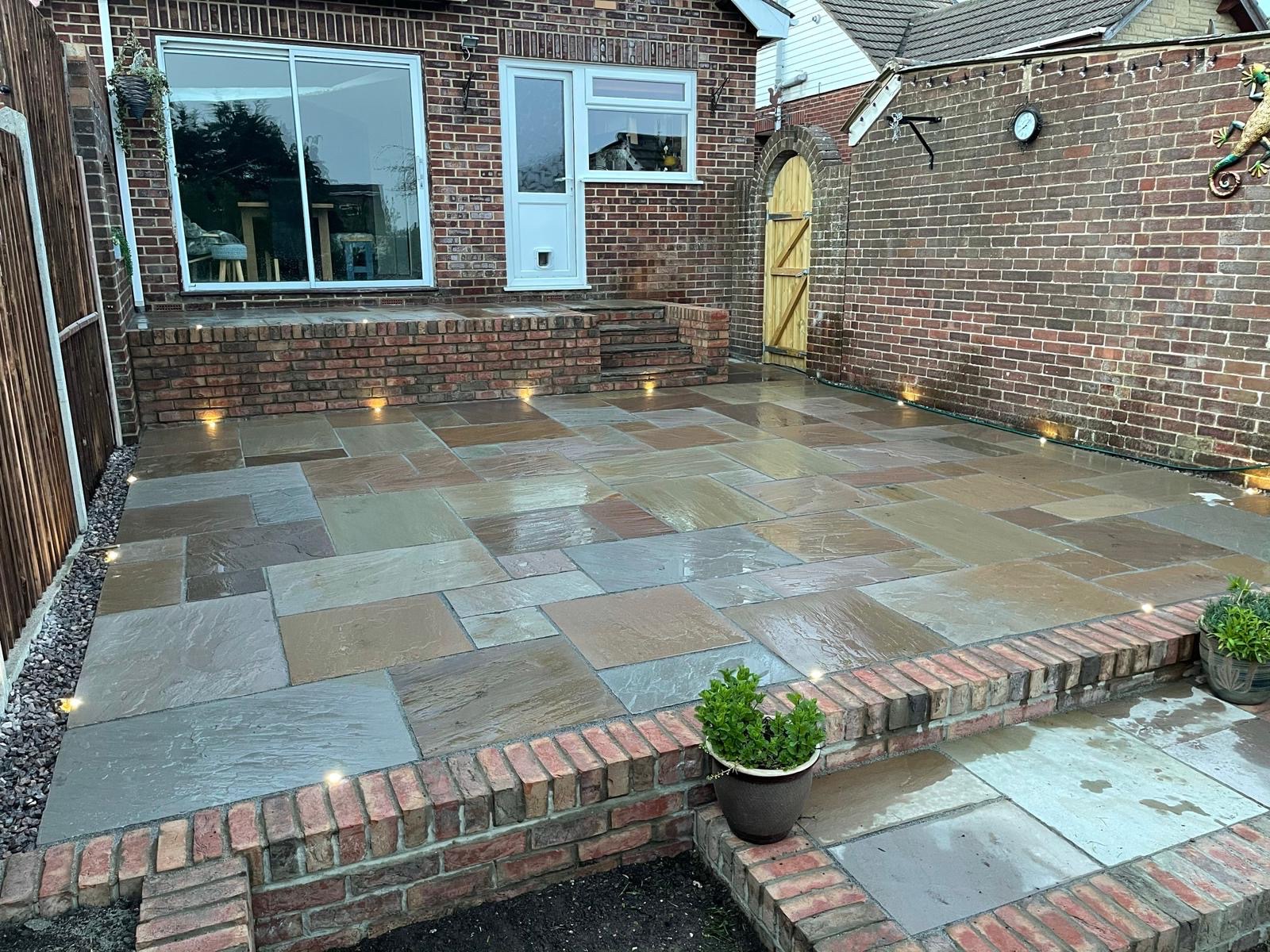 Natural stone courtyard patio with brick steps and integrated lighting