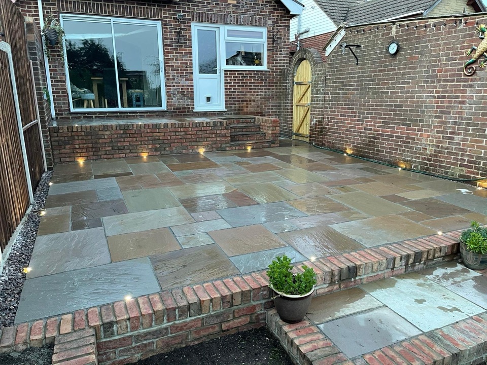 Natural stone courtyard patio with brick steps and integrated lighting